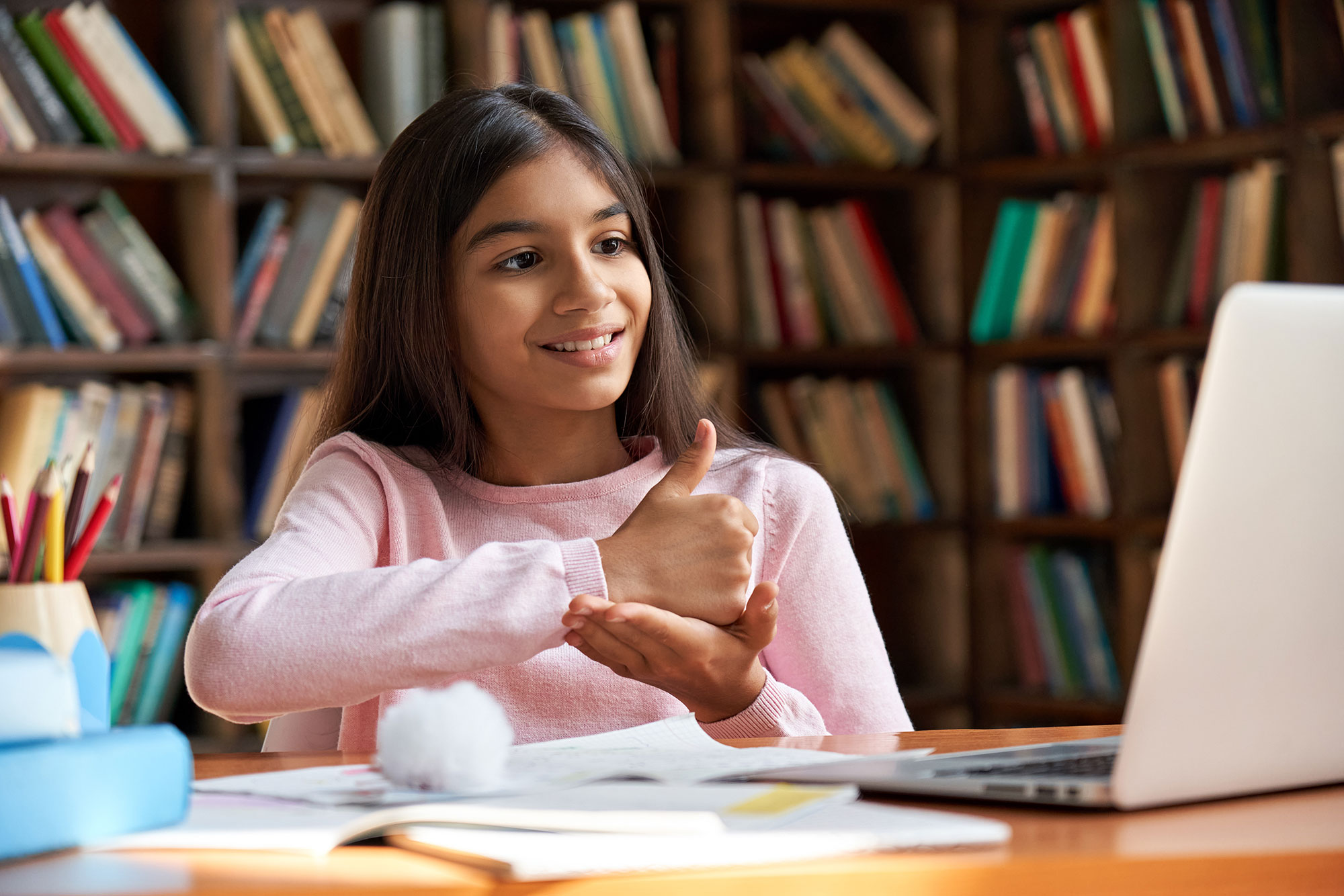 Young female student using sign language over a video call