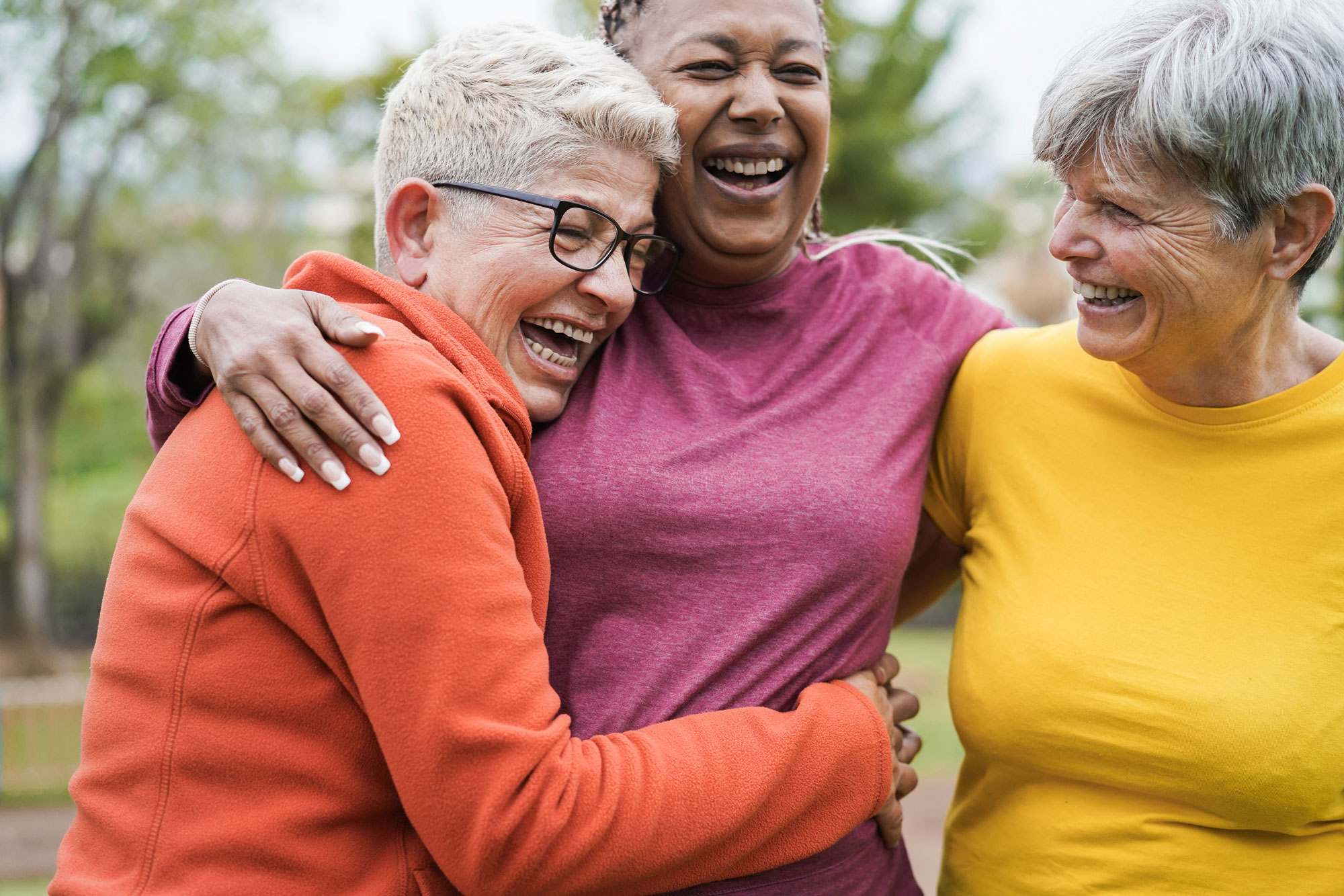 Older women embracing in friendly hug and smiling