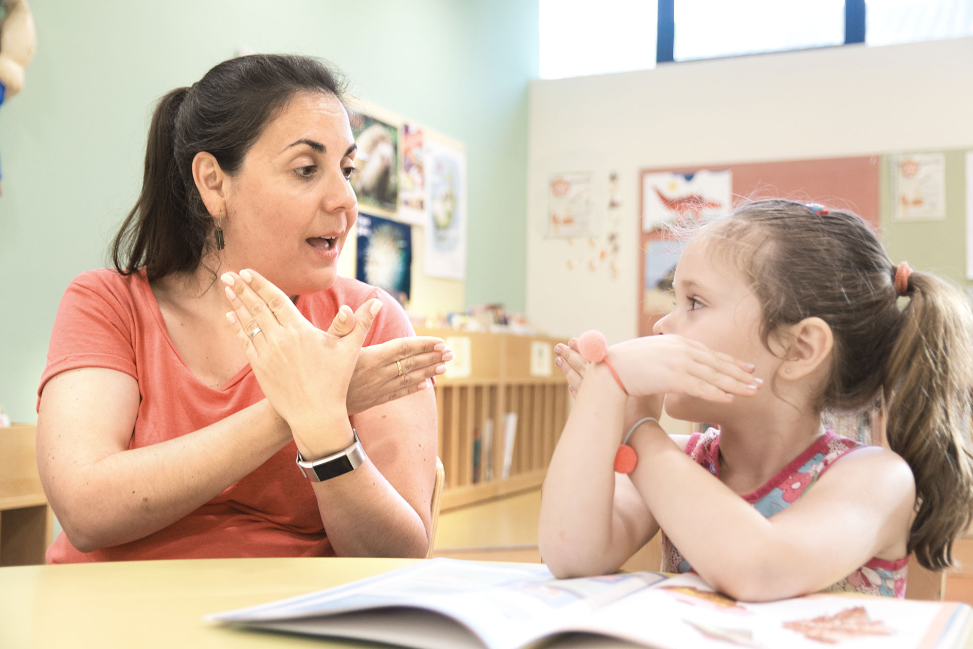 Teacher helping young student in a classroom