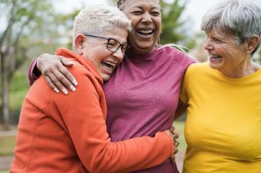 Three woman laughing while embracing
