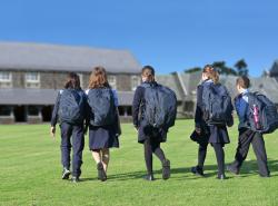 school children walking across yard to class