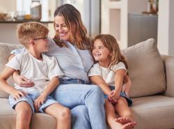 Mother sitting on sofa with young girl and boy