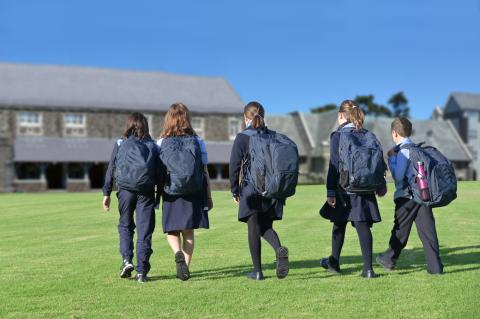 school children walking across yard to class