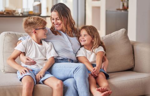 Mother sitting on sofa with young girl and boy